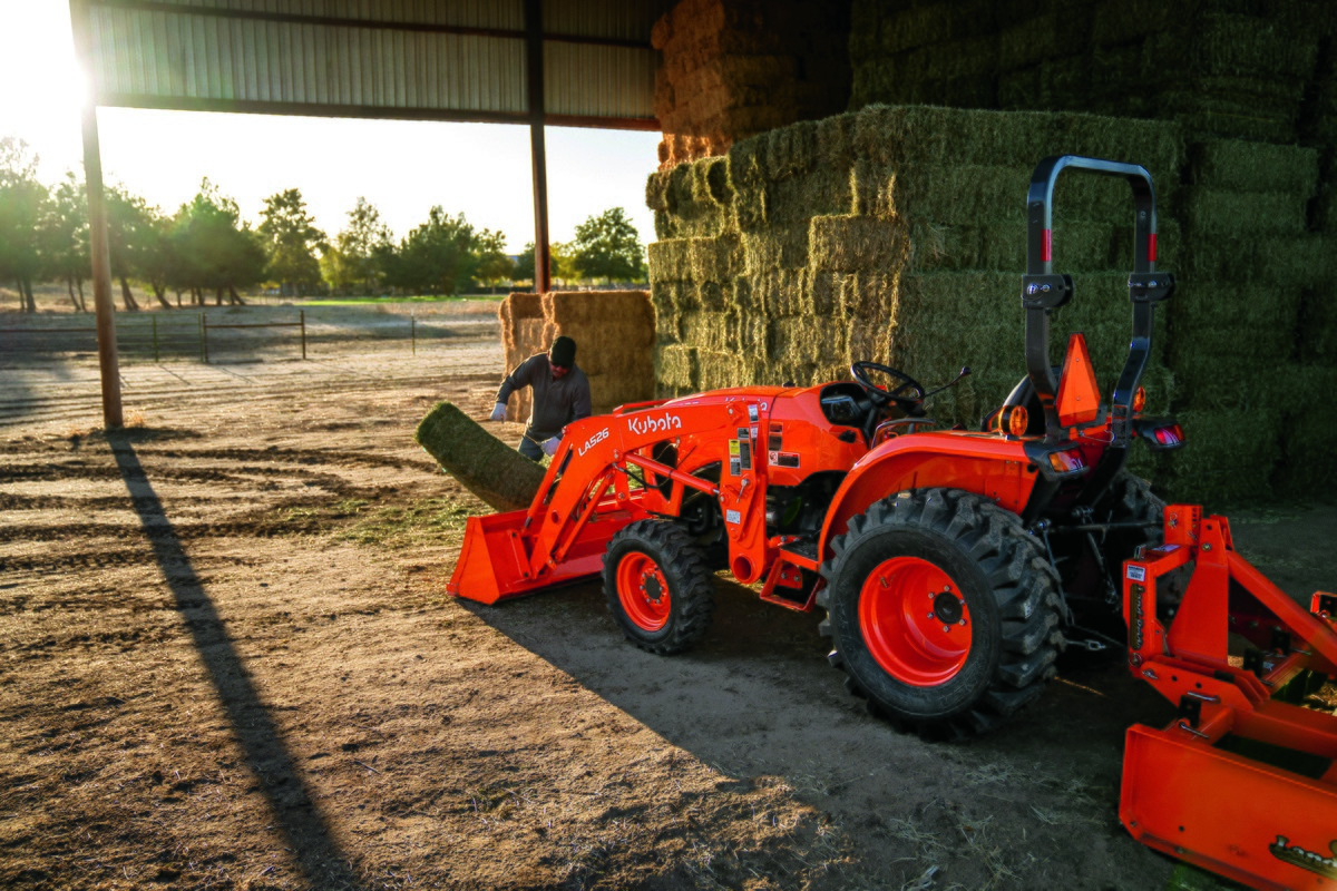 Man loads hay onto a Kubota L3302